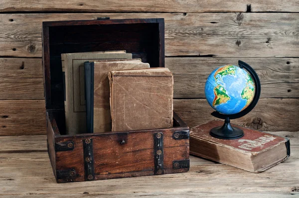 Old books in vintage chest closeup on wooden table