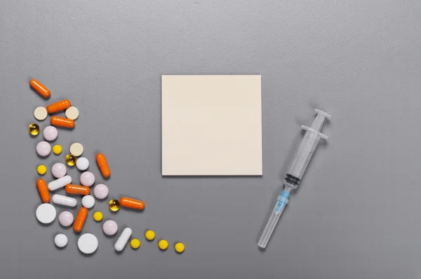 Paper for notes with a pills, capsules and syringe