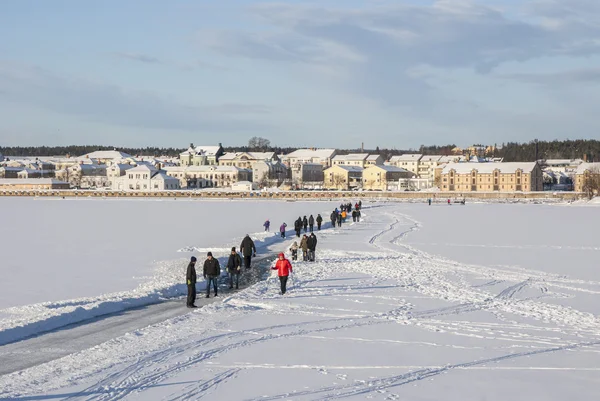 People walking on the frozen Baltic bay in Hudiksvall, Sweden