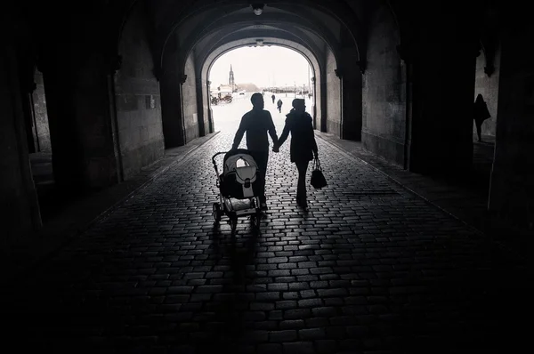 Happy family with baby walking in street, black and white