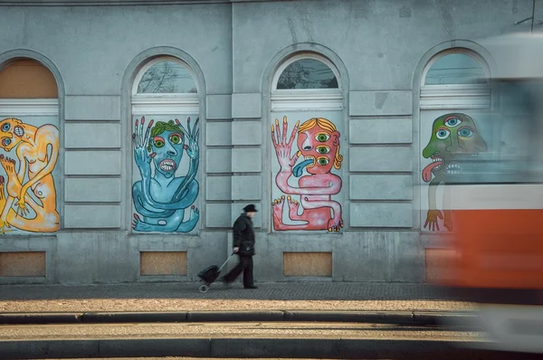 Tram, woman and building with graffiti