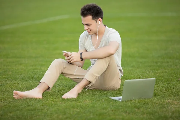 Man listening to music on green lawn