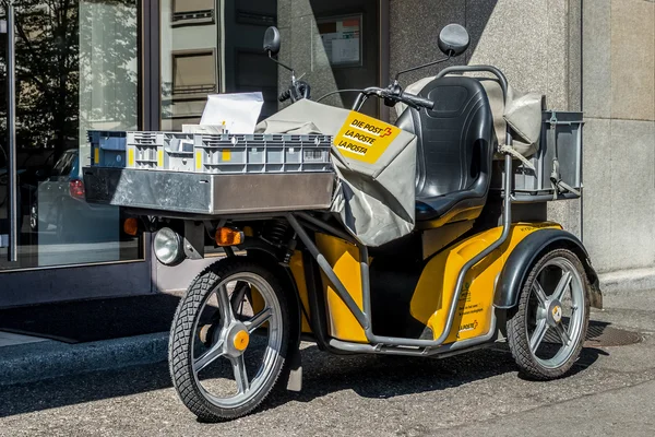 Switzerland, Geneva - June 2015. Swiss post delivery motorcycle on the street in the city center of Geneva. Swiss post is a public company owned by the Swiss Confederation