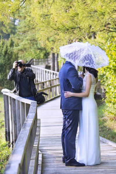 Wedding photographer taking photographs of groom and bride