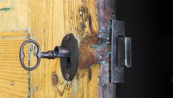 Old lock and key in a wooden door