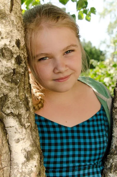 Russian beautiful girl, in the village, near the birch on a sunny day