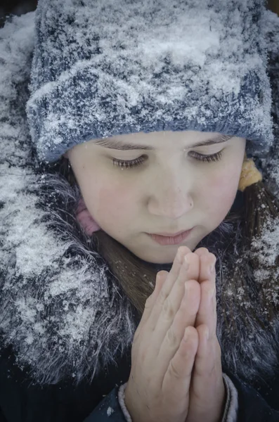 Beautiful girl in the snow warms hands