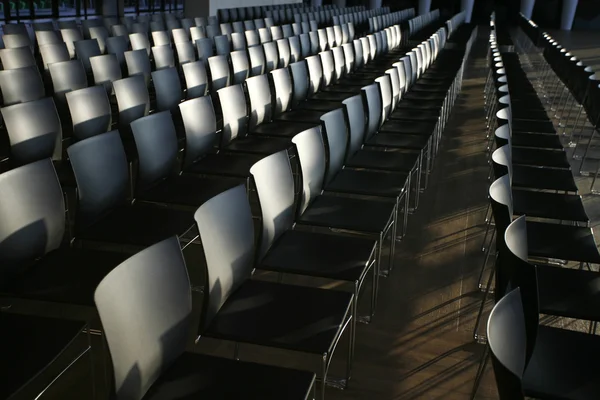 Rows of empty chairs prepared for an indoor event