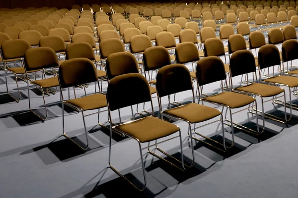 Empty chairs of an auditorium in a congress hall in row