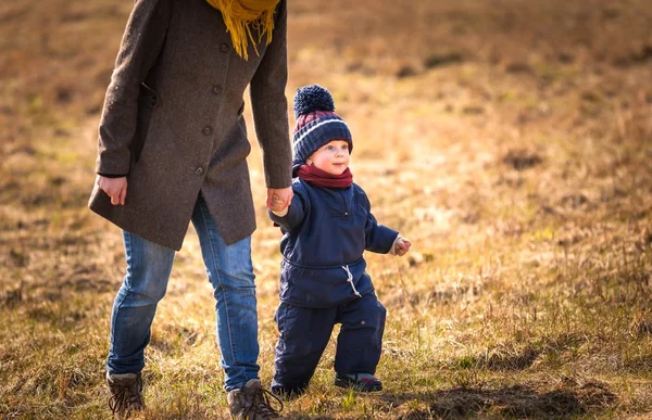 Happy caucasian child playing outdoor - walking with his mother