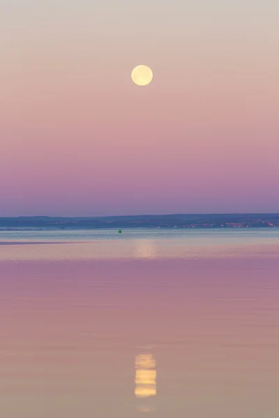 Moon setting over sea.