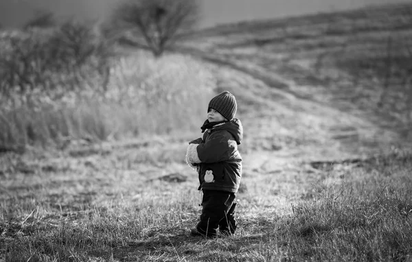 Young happy boy playing outdoor. Black and white photo.