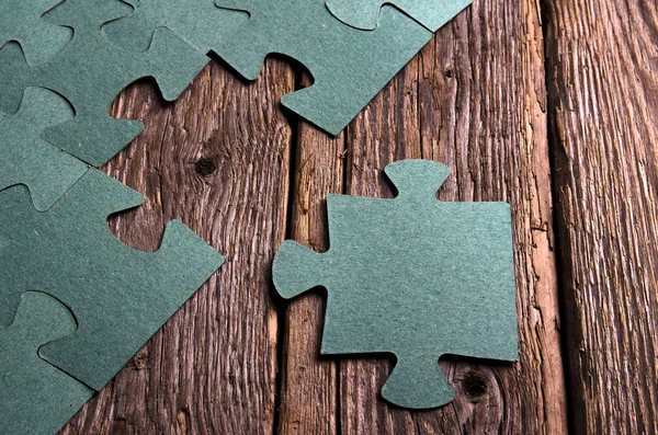 Incomplete puzzles lying on wooden rustic boards.