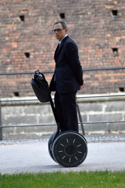 Businessman standing on electric scooter