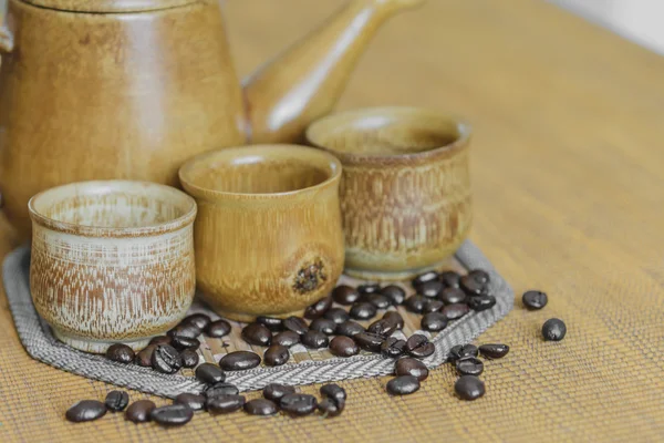 Soft focus image of coffee beans and coffee cups set on wooden b