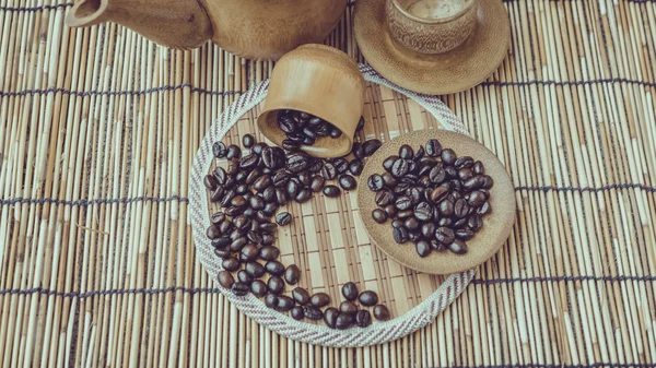 Coffee beans and coffee cup set on bamboo wooden background.Phot