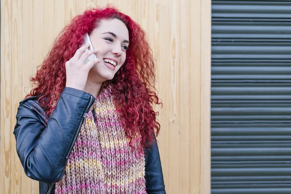 Portrait of attractive young woman with mobile phone in the stre