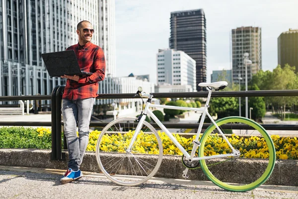 Man with laptop and fixed gear bicycle