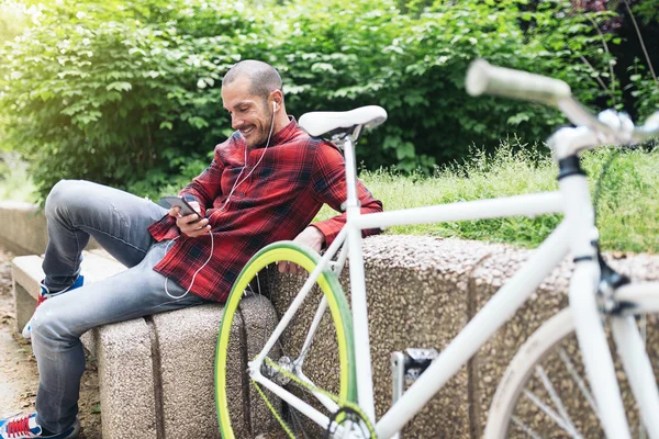 Man with mobile phone and bicycle.