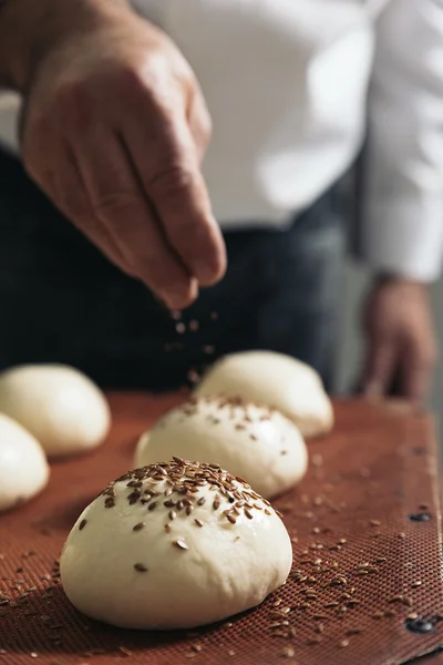 Baker kneading dough in a bakery.