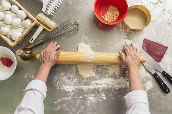 Baker kneading dough in a bakery.