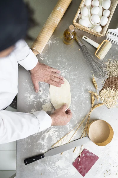 Baker kneading dough in a bakery.