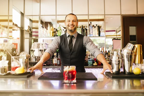 Barman is making cocktail at night club.