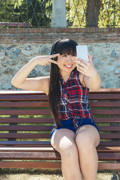 Asian woman taking self portrait selfie photo on park.