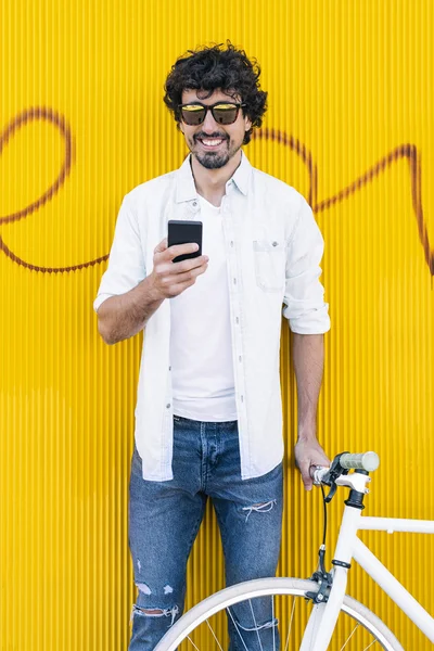 Handsome young man with mobile phone and fixed gear bicycle.