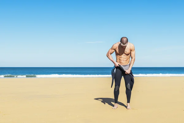 Swimmer putting on his wetsuit