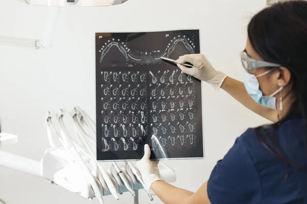 Doctor talking with her patient and teaching a radiograph.