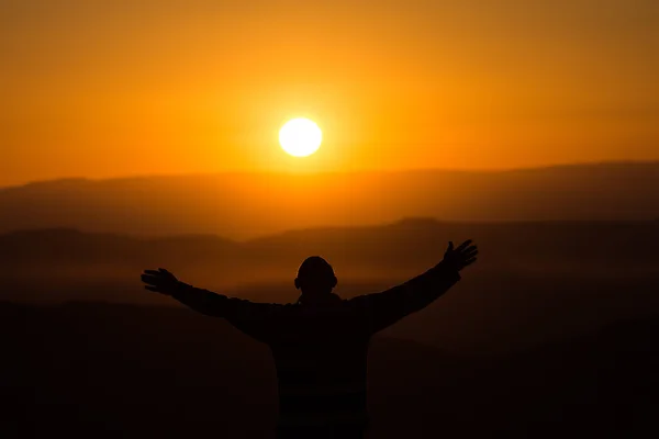 Silhouette of a man on background of sunrise in the desert