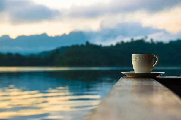 Cup of coffee with lake on the background