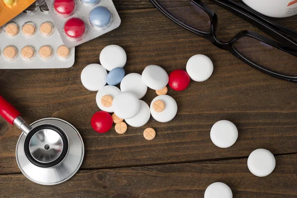 Stethoscope , tablets , vitamins and glasses top view
