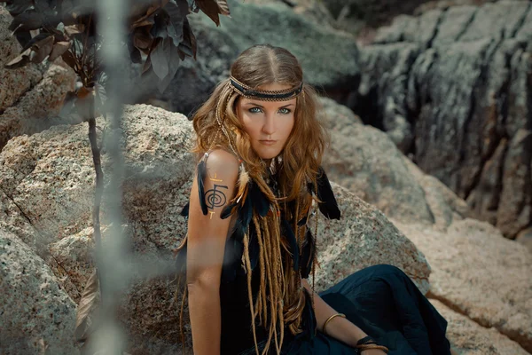 Young beautiful boho woman on the rocks