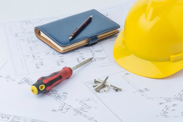 Yellow safety helmet, notebook and screwdriver