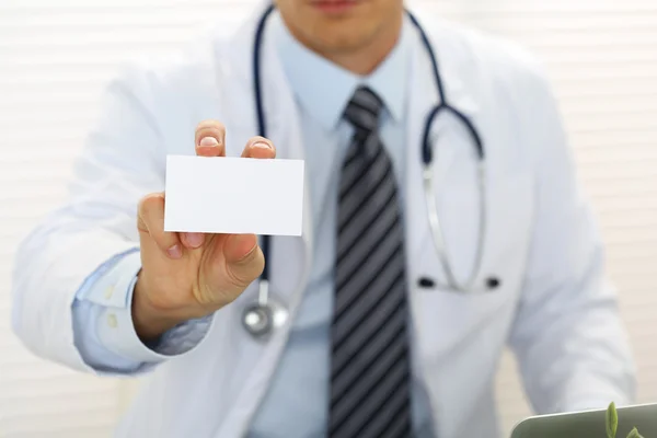 Male physician hand holding and giving white blank calling card