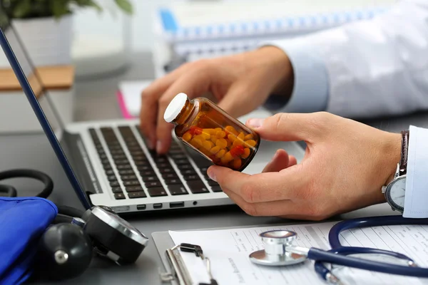 Male medicine doctor hands hold jar of pills
