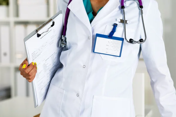 Stethoscope lying on female doctor chest in office
