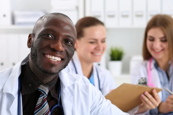 Portrait of young handsome black male doctor with colleagues