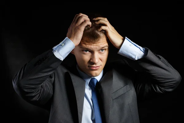 Businessman in suit tearing his hair with hands