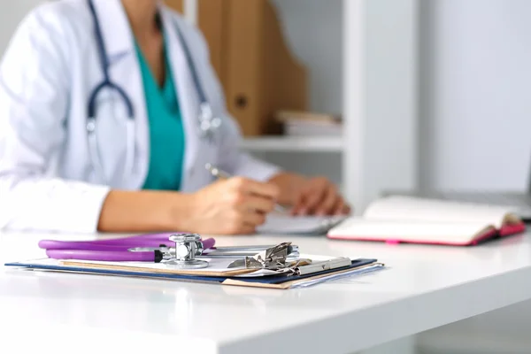 Stethoscope head lying on medical forms