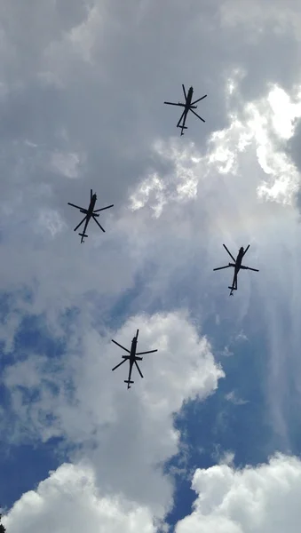 Helicopters in cloudy sky
