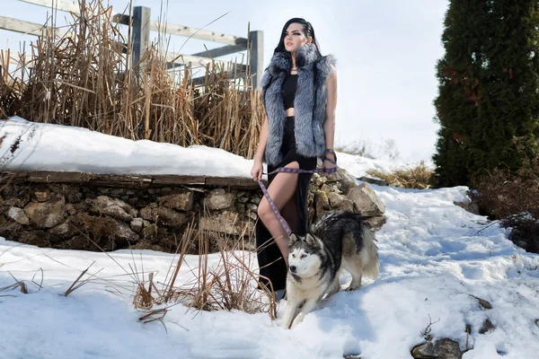 Elegant girl in a fur vest with the Laika dog