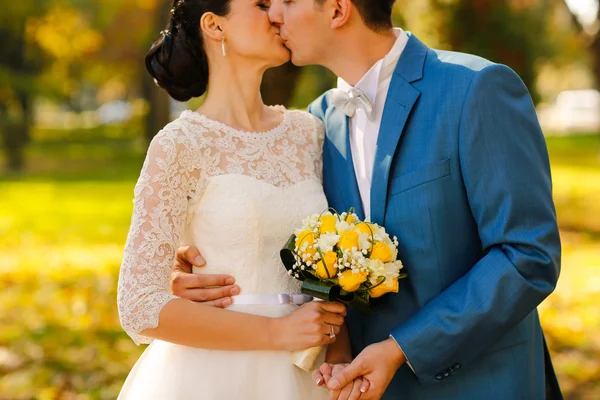 Groom and bride kissing in the park