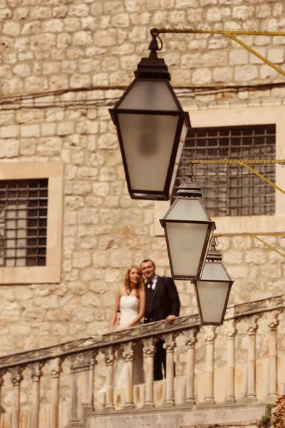 Bride and groom kissing on stairs in old city