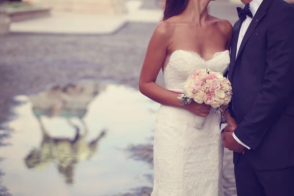 Bride and groom holding hands in the city