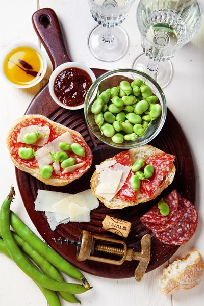 Italian snacks. salami sandwich with parmesan cheese & broad bea