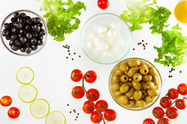 Different types of olives and mozzarella with cherry tomatoes an
