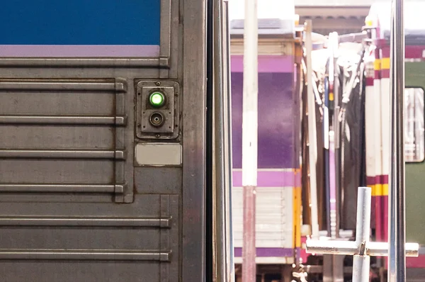 Open door button and blurred Thai diesel train as background